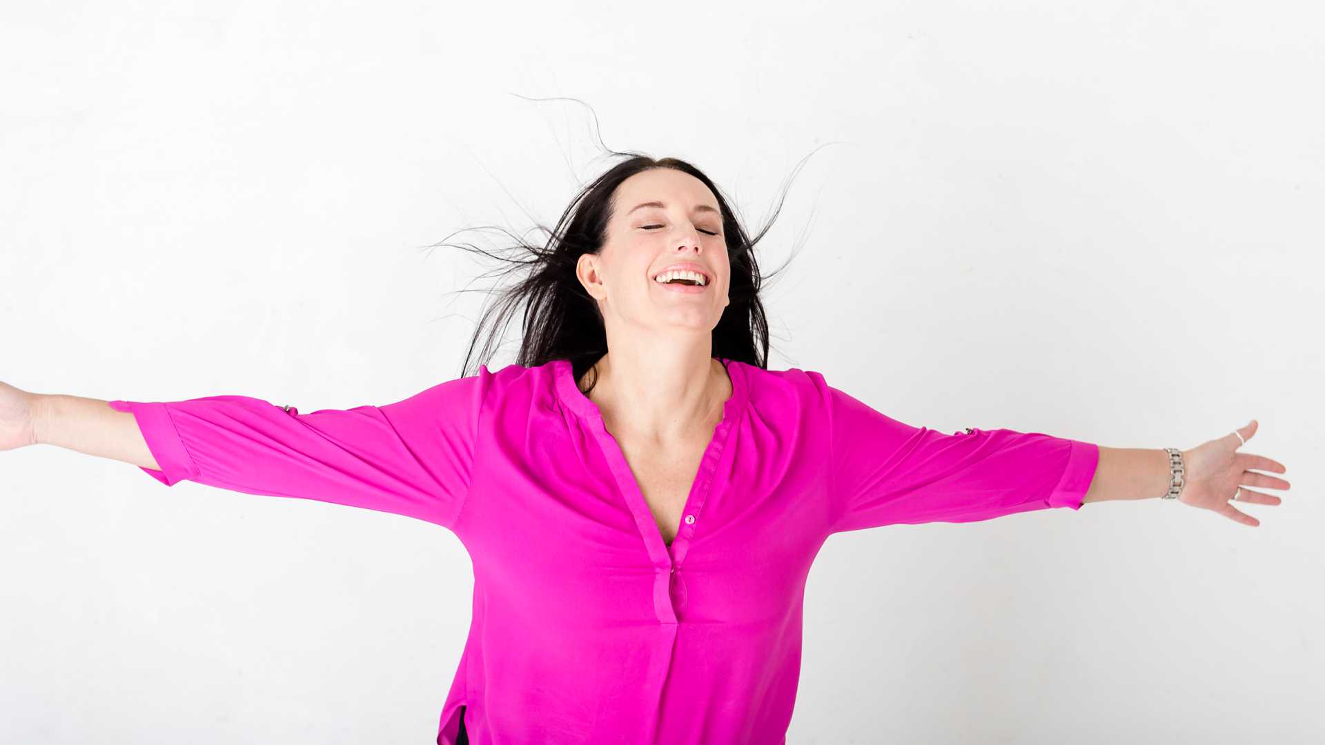 joyous relaxed business portrait of female business owner in pink shirt