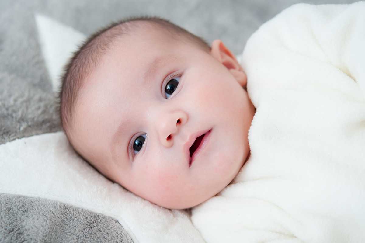 young baby with dark eyes staring at camera