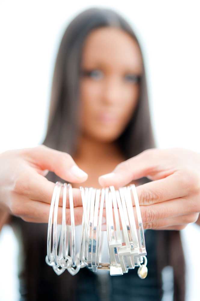 model holding selection of silver bracelets up to camera