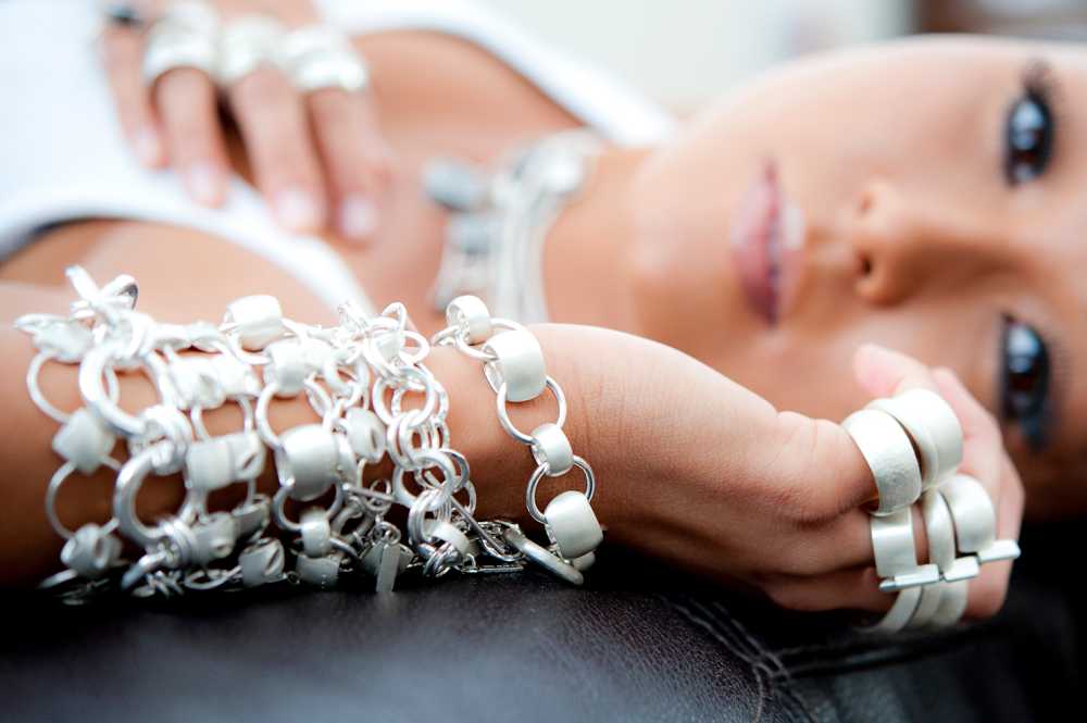 silver jewellery, bracelets, necklaces and rings designed by TLK.com model lying down looking at camera