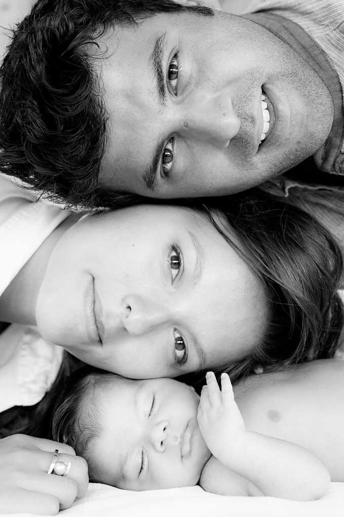 parents and young baby, heads touching - black and white