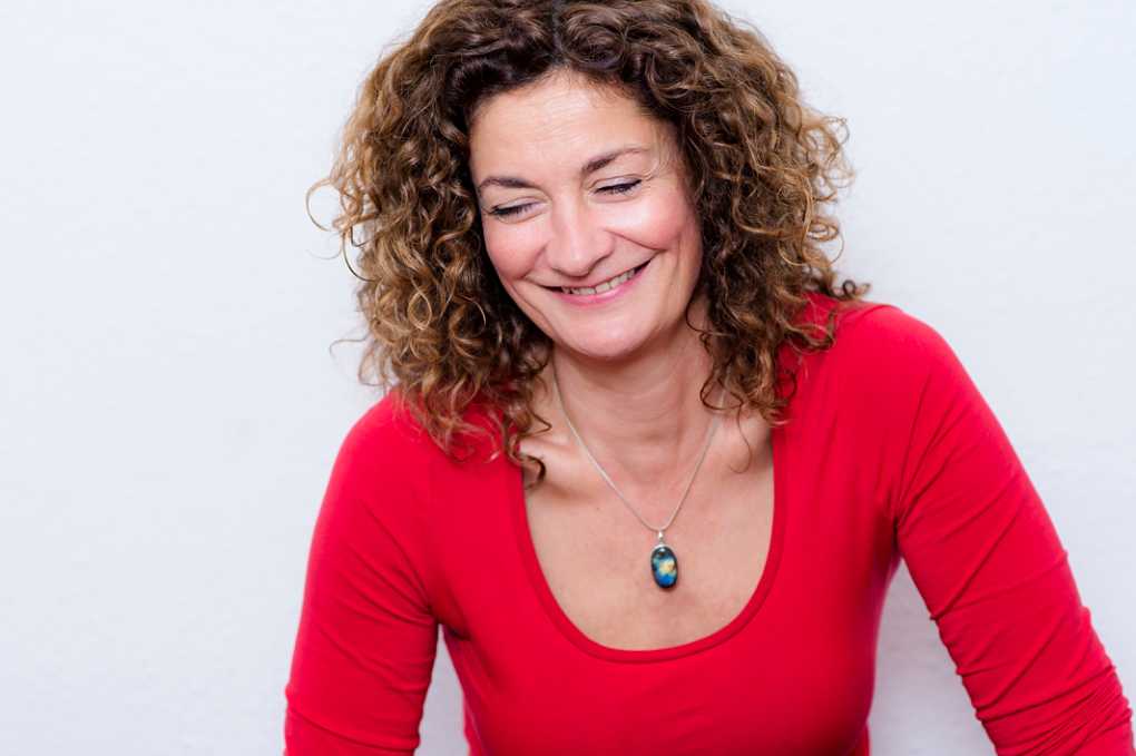 relaxed professional portrait of therapist, curly hair, red top